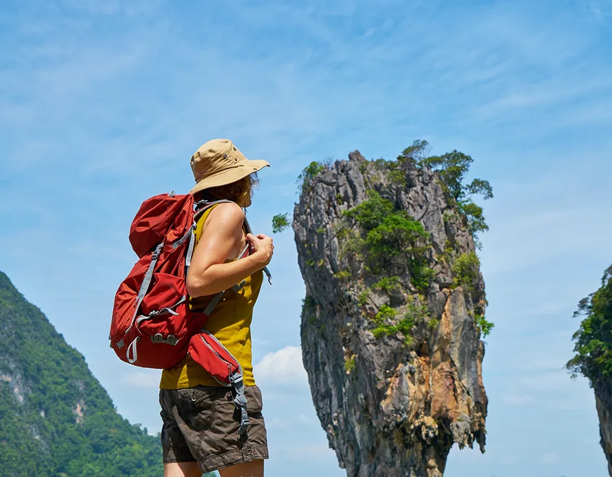 Traveler exploring tropical island cliffs
